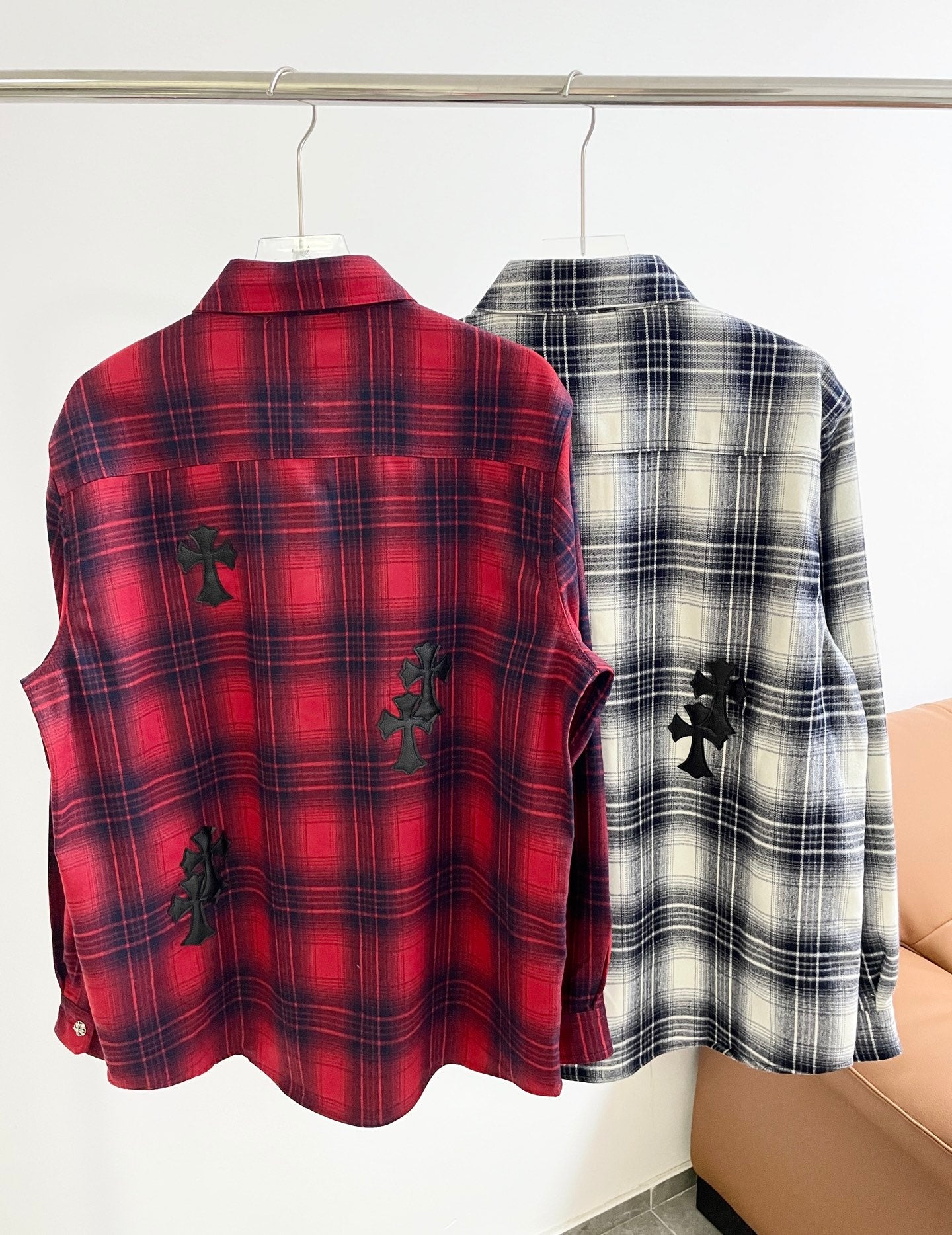 Red plaid button-up shirt showing back view with black embroidered motifs