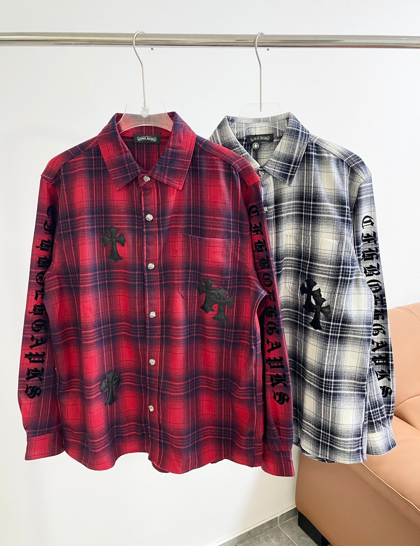 Red plaid button-up shirt with long sleeves and black embroidered motifs