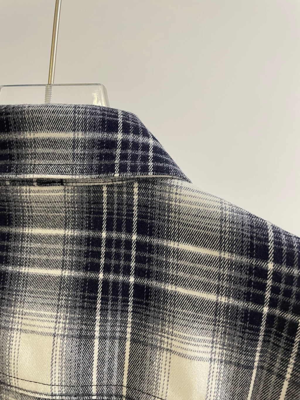 Blue plaid shirt shoulder with button-up yoke and plaid pattern texture