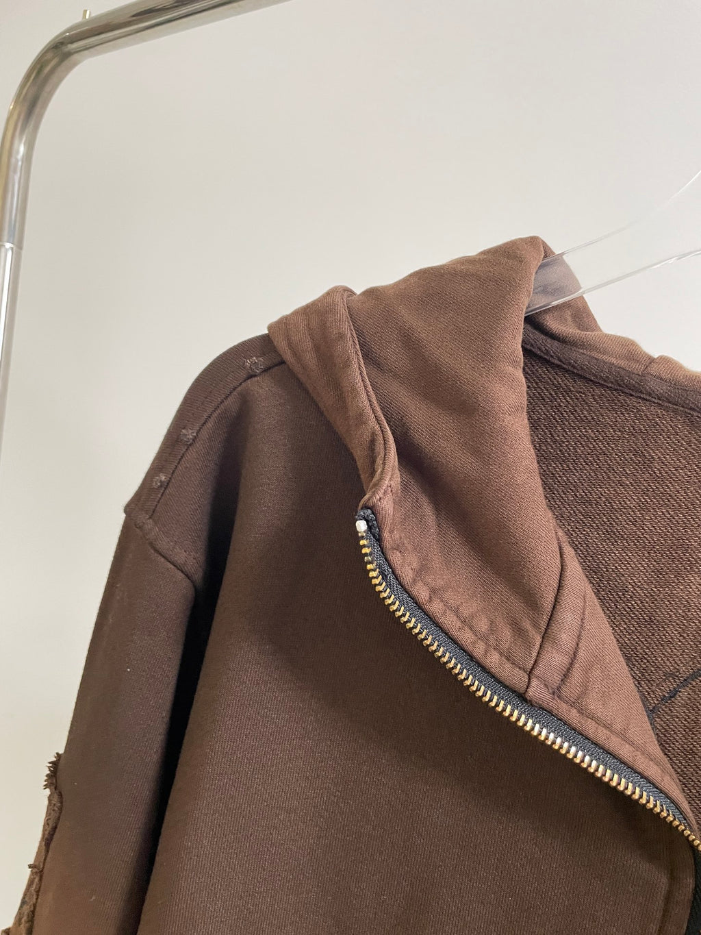 Brown hoodie shoulder and hood with gold zipper trim