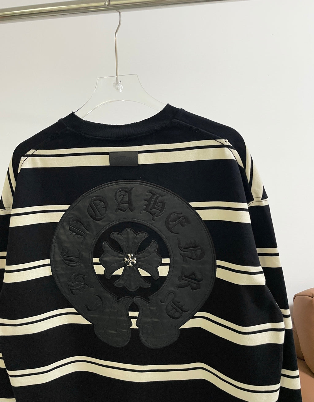 Navy long-sleeve striped shirt with large circular black crest patch and crew neck