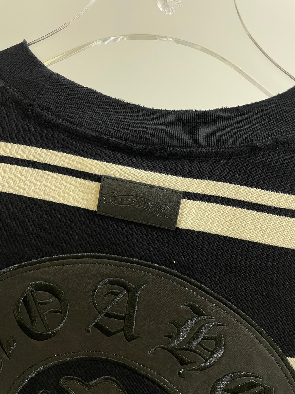 Navy striped long-sleeve shirt with woven label at neckline and textured crest patch