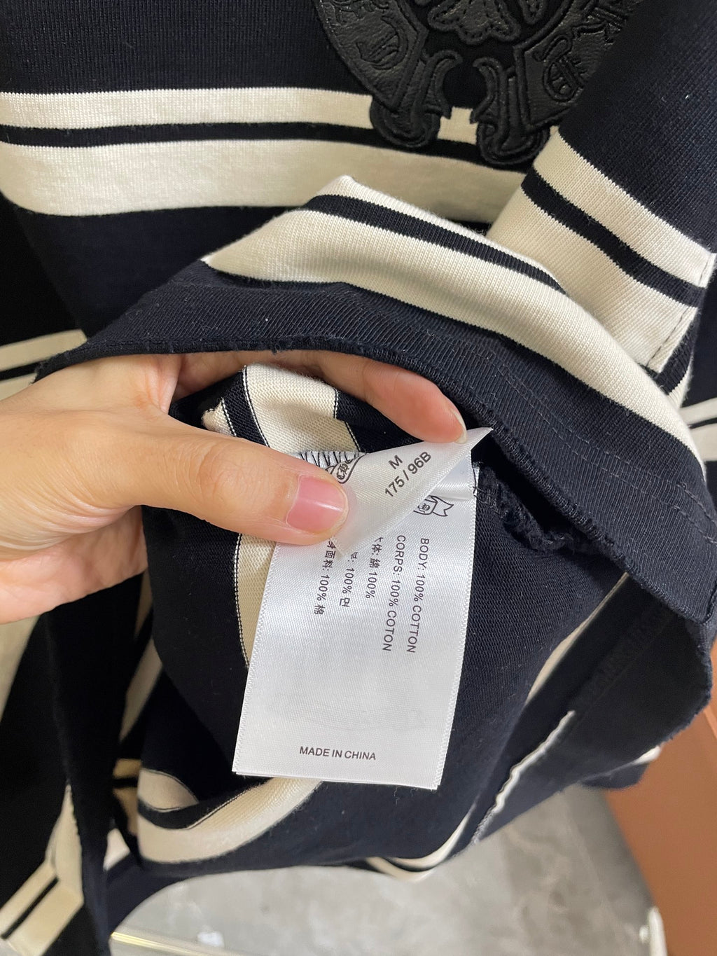 Clothing size label inside navy and cream striped long-sleeve shirt