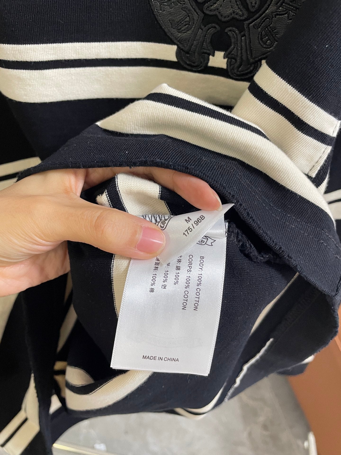 Clothing size label inside navy and cream striped long-sleeve shirt