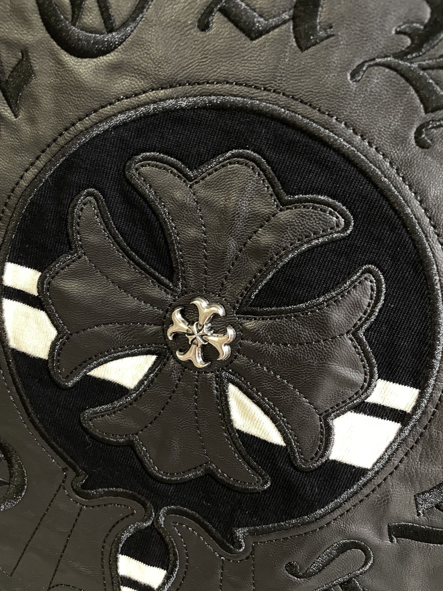 Embroidered flower emblem on dark circular crest patch with stitched border