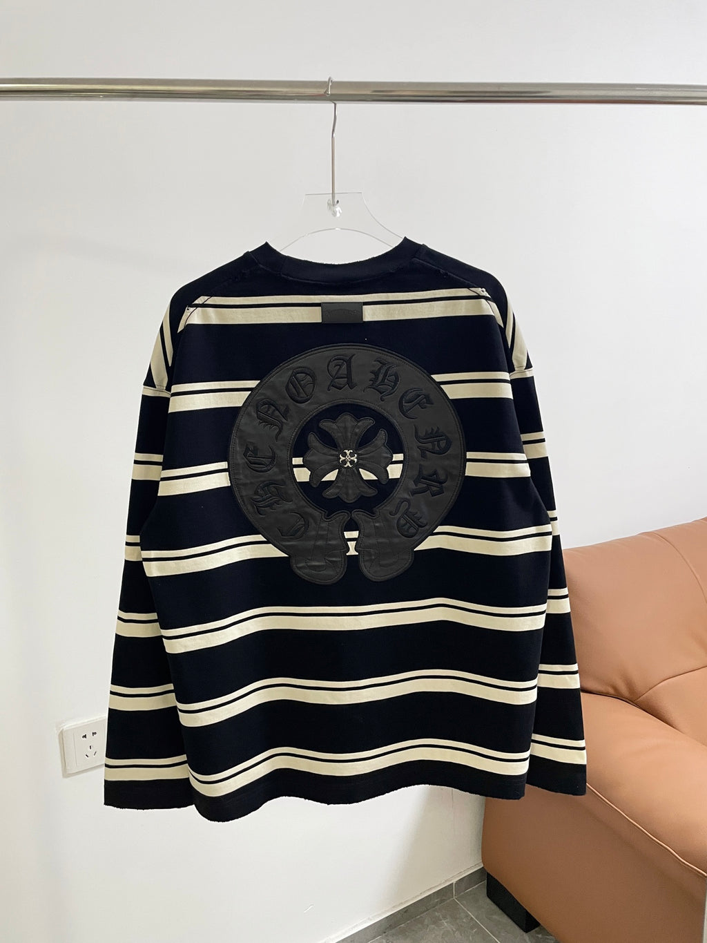 Navy long-sleeve striped shirt with large dark circular crest patch across chest