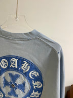 Back view of light blue long-sleeve shirt with blue embroidered circular shoulder logo