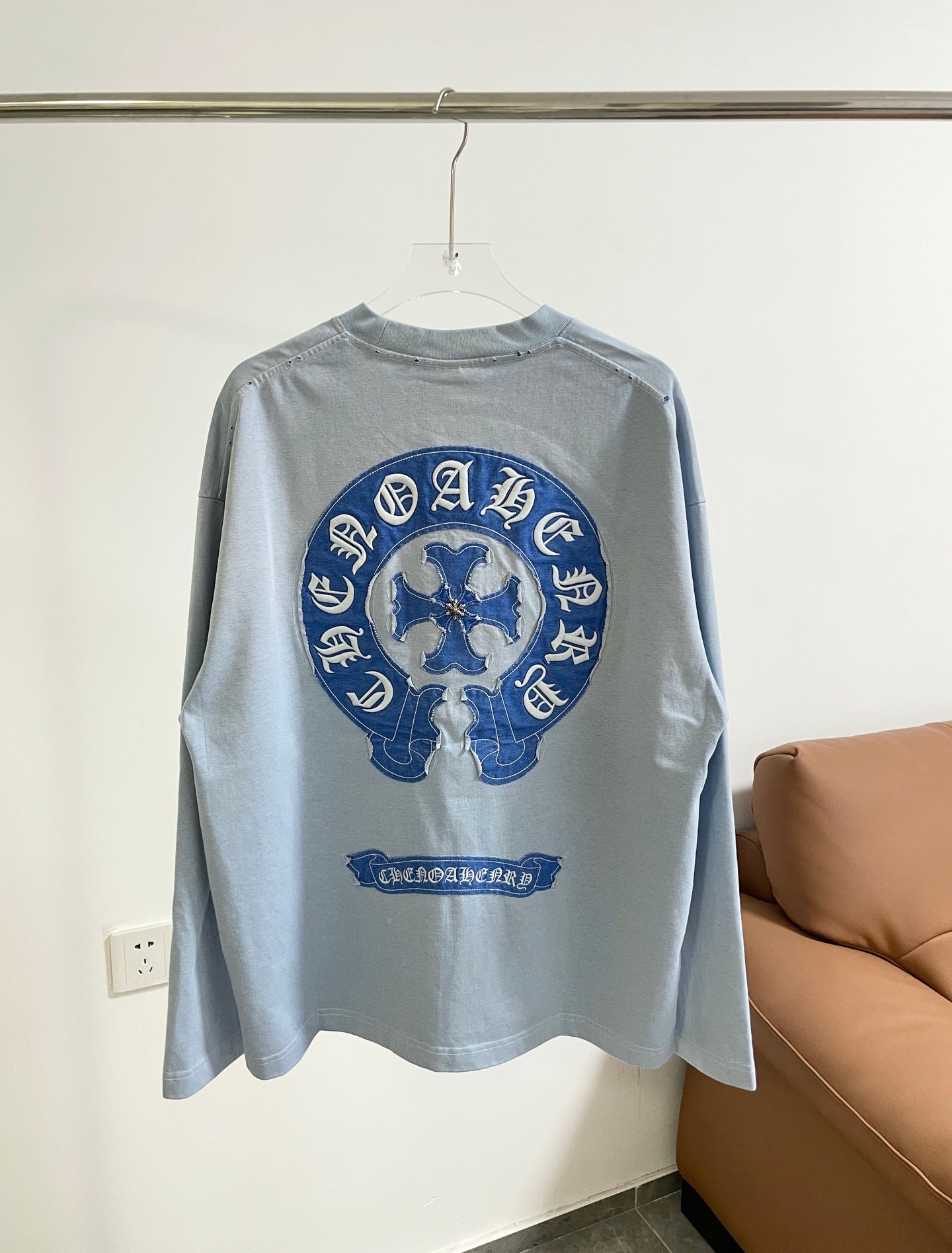 Light blue long-sleeve T-shirt back with large blue circular graphic and text below.