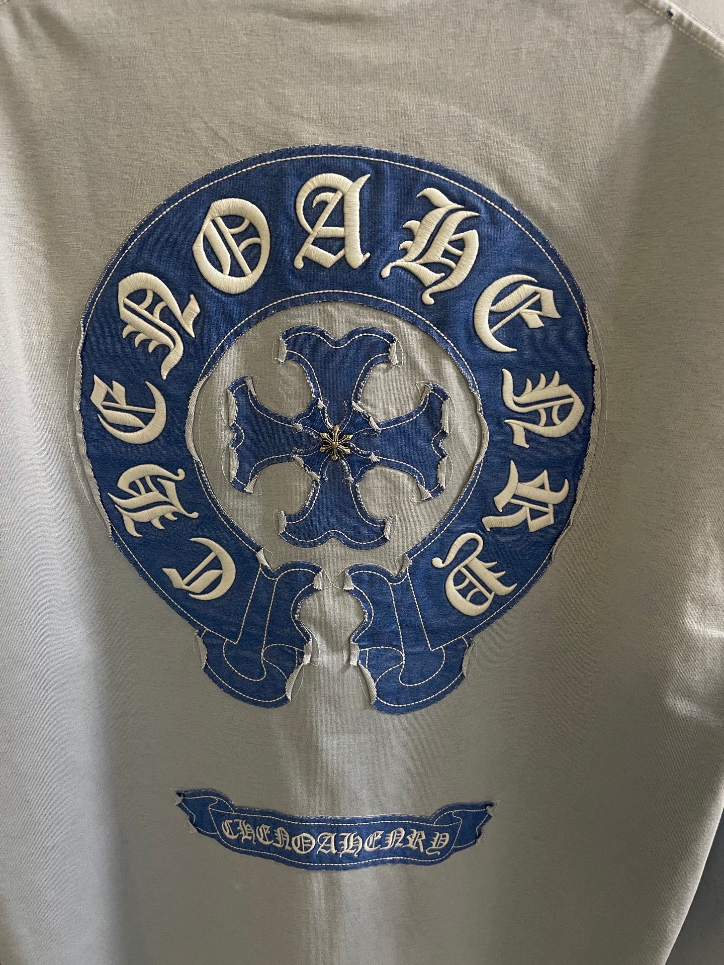 Light blue long-sleeve shirt with large round blue embroidered back logo