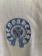 Embroidered blue elephant-style logo on light blue long-sleeve shirt fabric