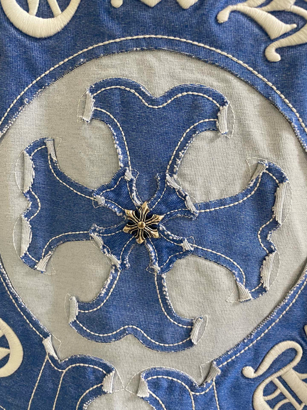 Close-up of blue embroidered flower-shaped elephant-style head on shirt logo