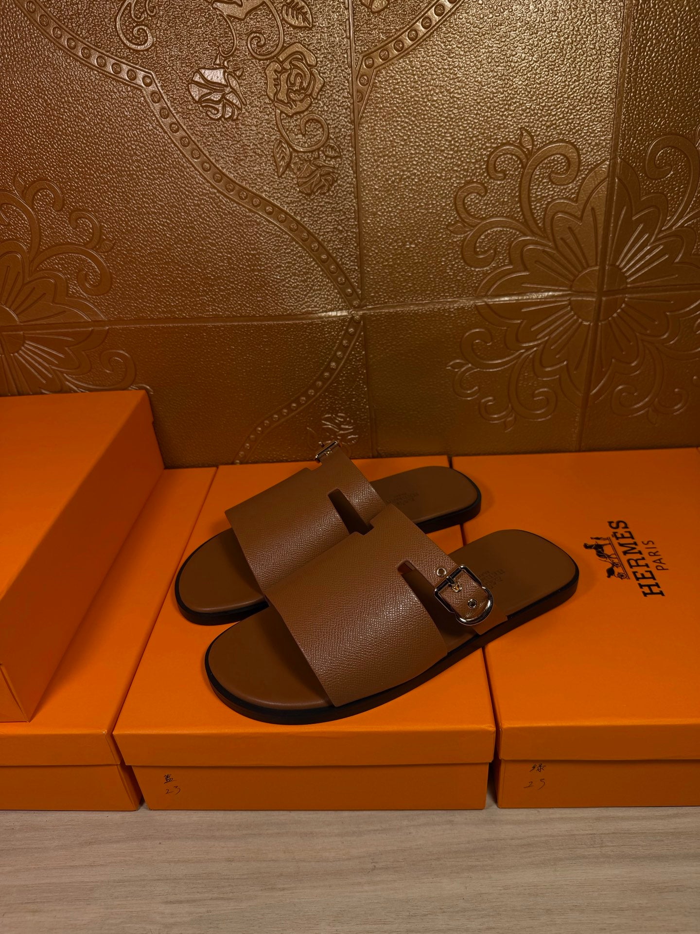 Brown leather slide sandals with double straps and silver buckle, shown from side