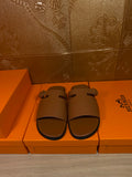 Brown leather slide sandals with two wide straps and silver buckle hardware
