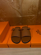Brown leather slide sandals with two wide straps and silver buckle hardware