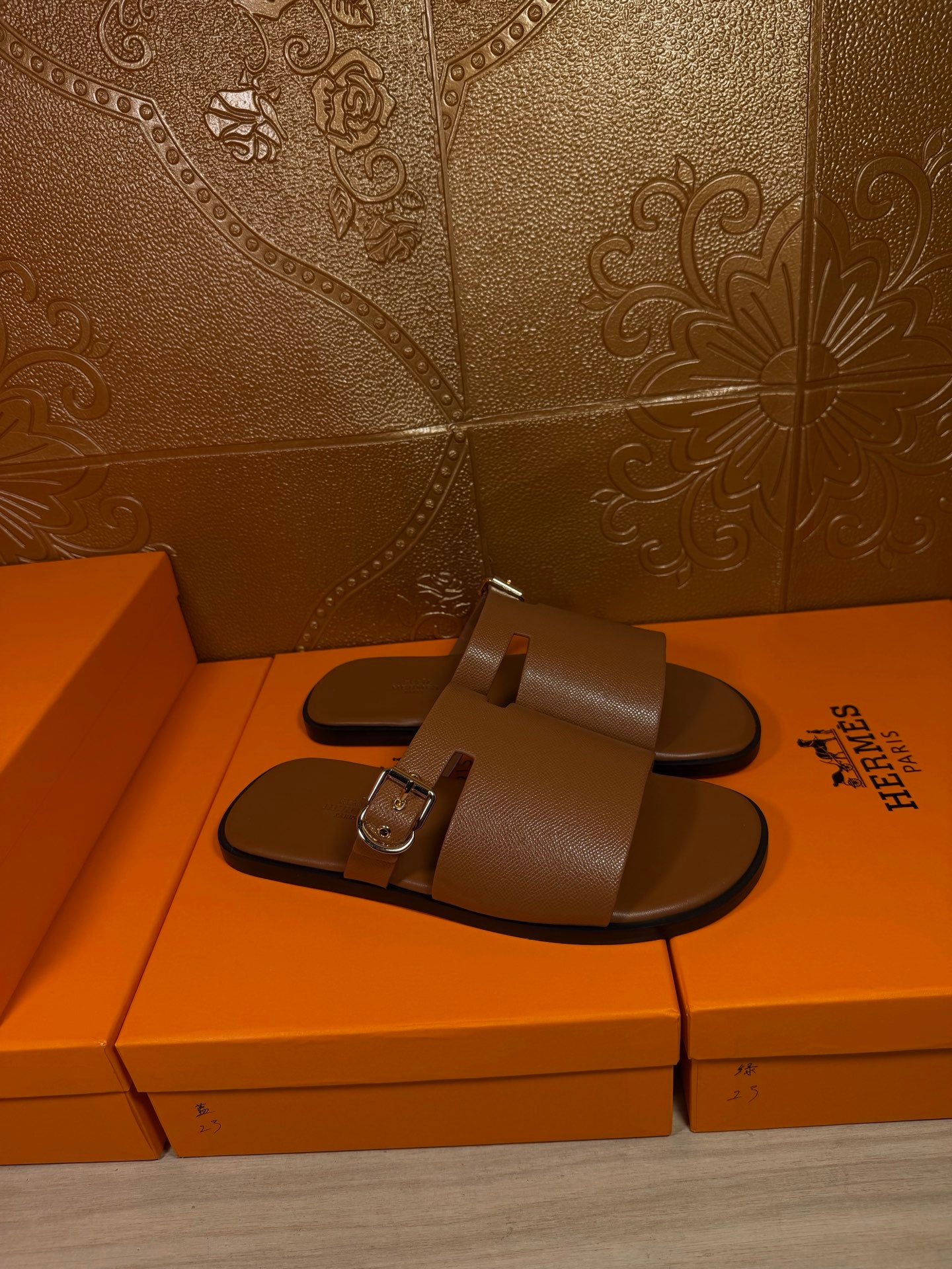 Brown leather slide sandals with wide strap and silver buckle detail, front view