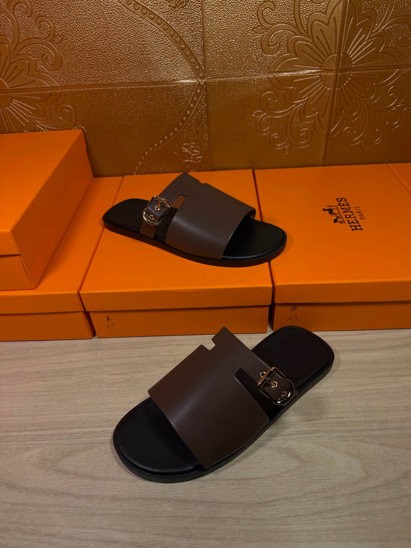 Dark brown leather slide sandals with metal buckle, two pairs on display