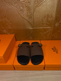 Dark brown leather slide sandals with wide straps and silver-tone buckle