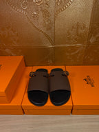 Dark brown leather slide sandals with wide straps and silver-tone buckle
