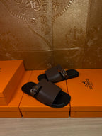Dark brown leather slide sandals with metal buckle on wide band