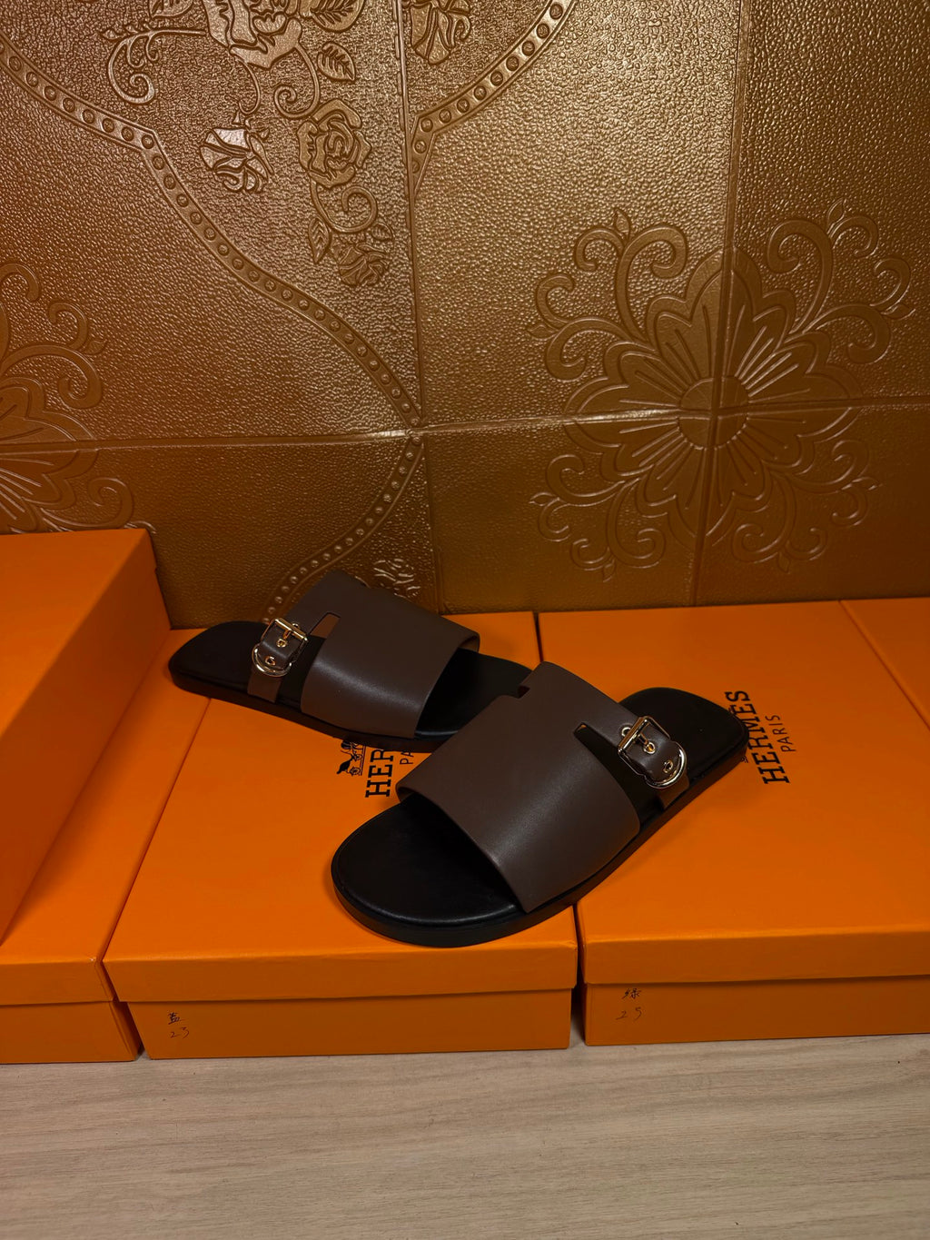 Dark brown slide sandals with wide strap and silver buckle, open toe