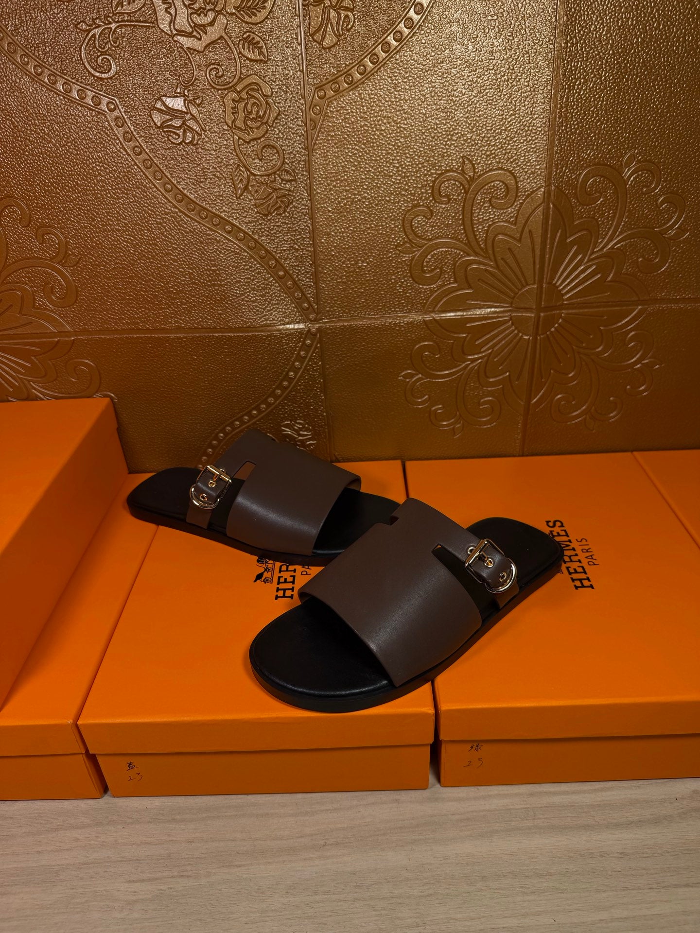 Dark brown slide sandals with wide strap and silver buckle, open toe