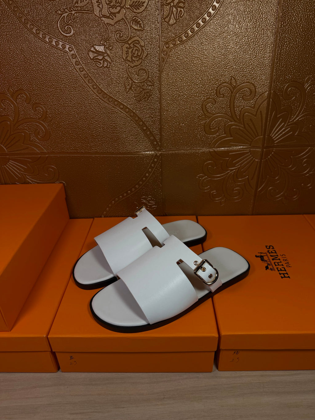 White slide sandals with front strap and side buckle, flat open-toe sole