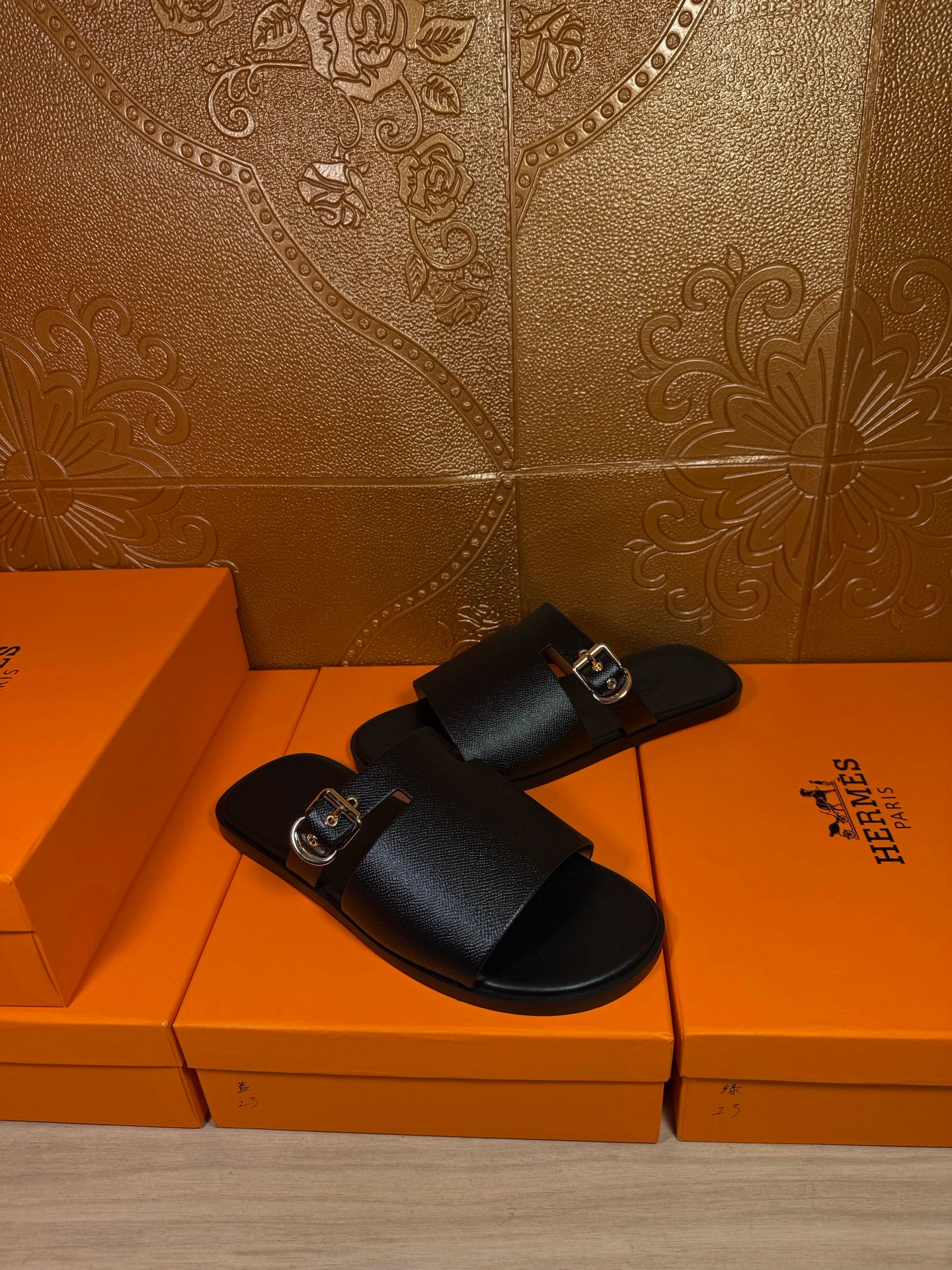 Black leather slide sandals with buckled strap and open toe, side view