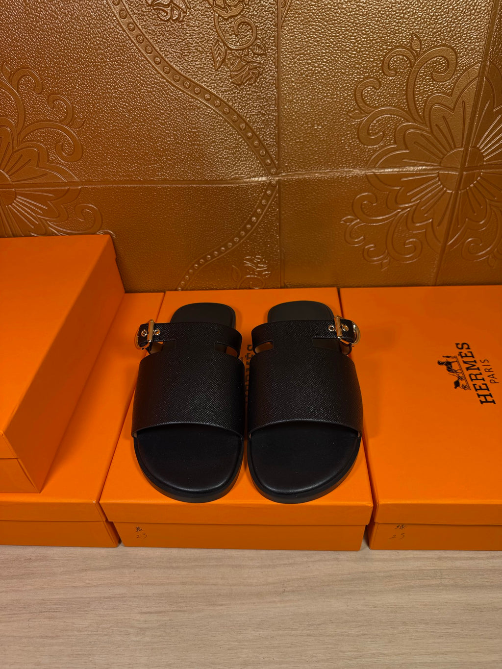 Black leather slide sandals with wide strap and silver-tone buckle