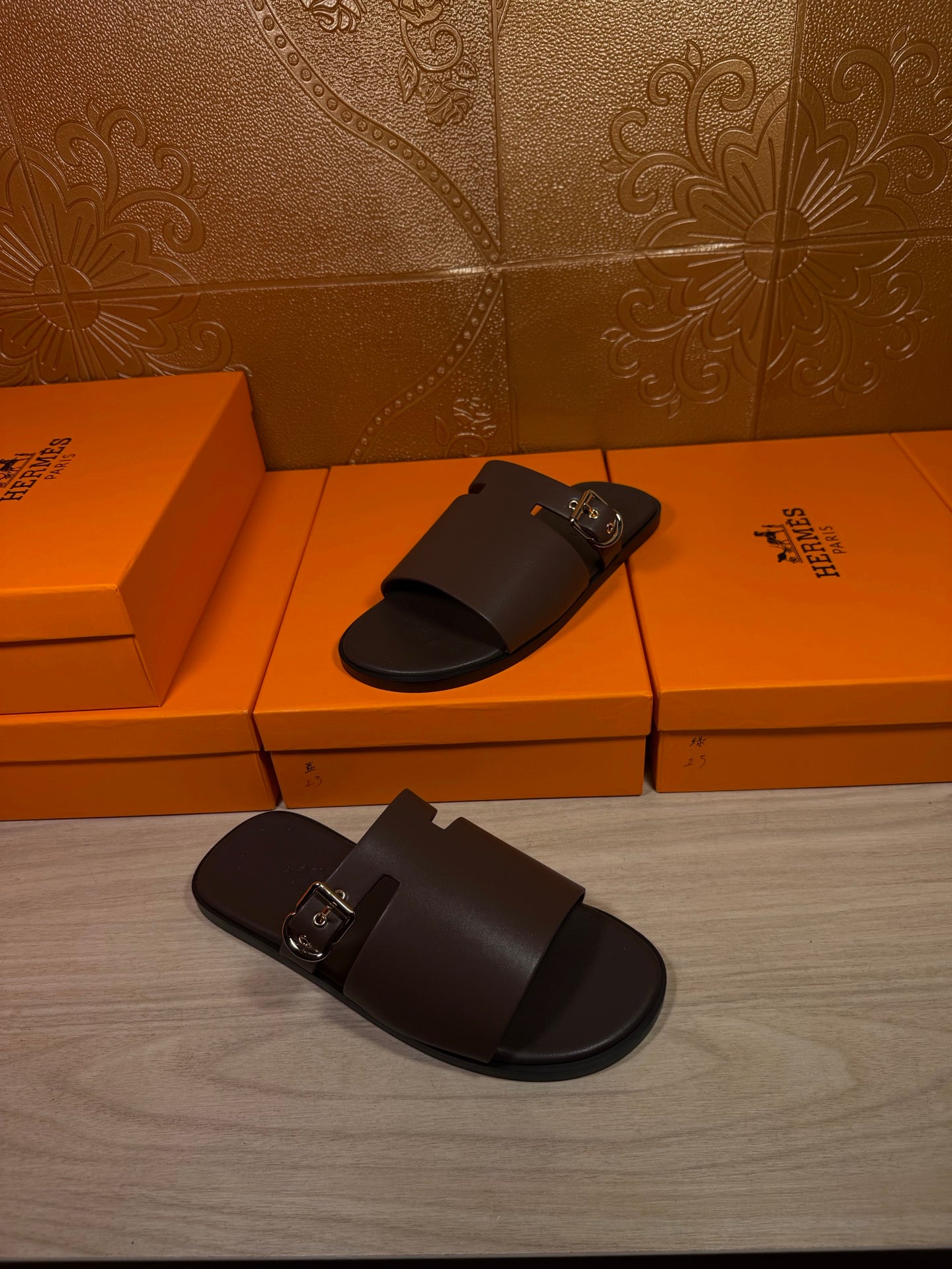 Hermes dark leather slide sandals with front buckle and wide foot strap