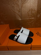 Hermes sandals with white single strap and black footbeds, front view on box