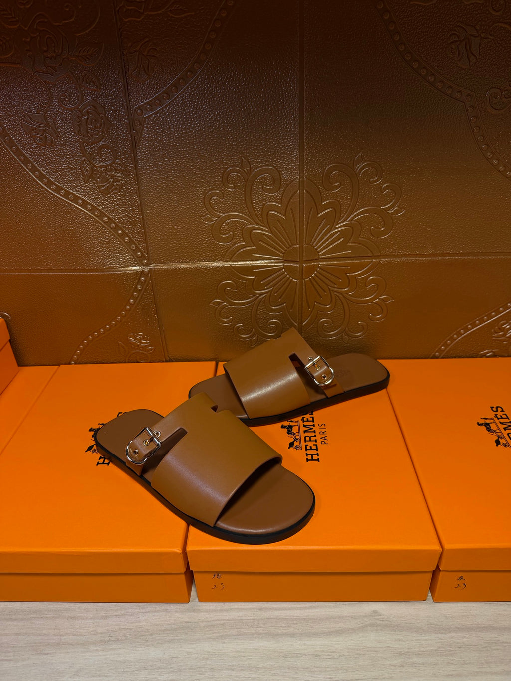 Hermes leather slide sandals with two silver buckles on wide straps, dark brown