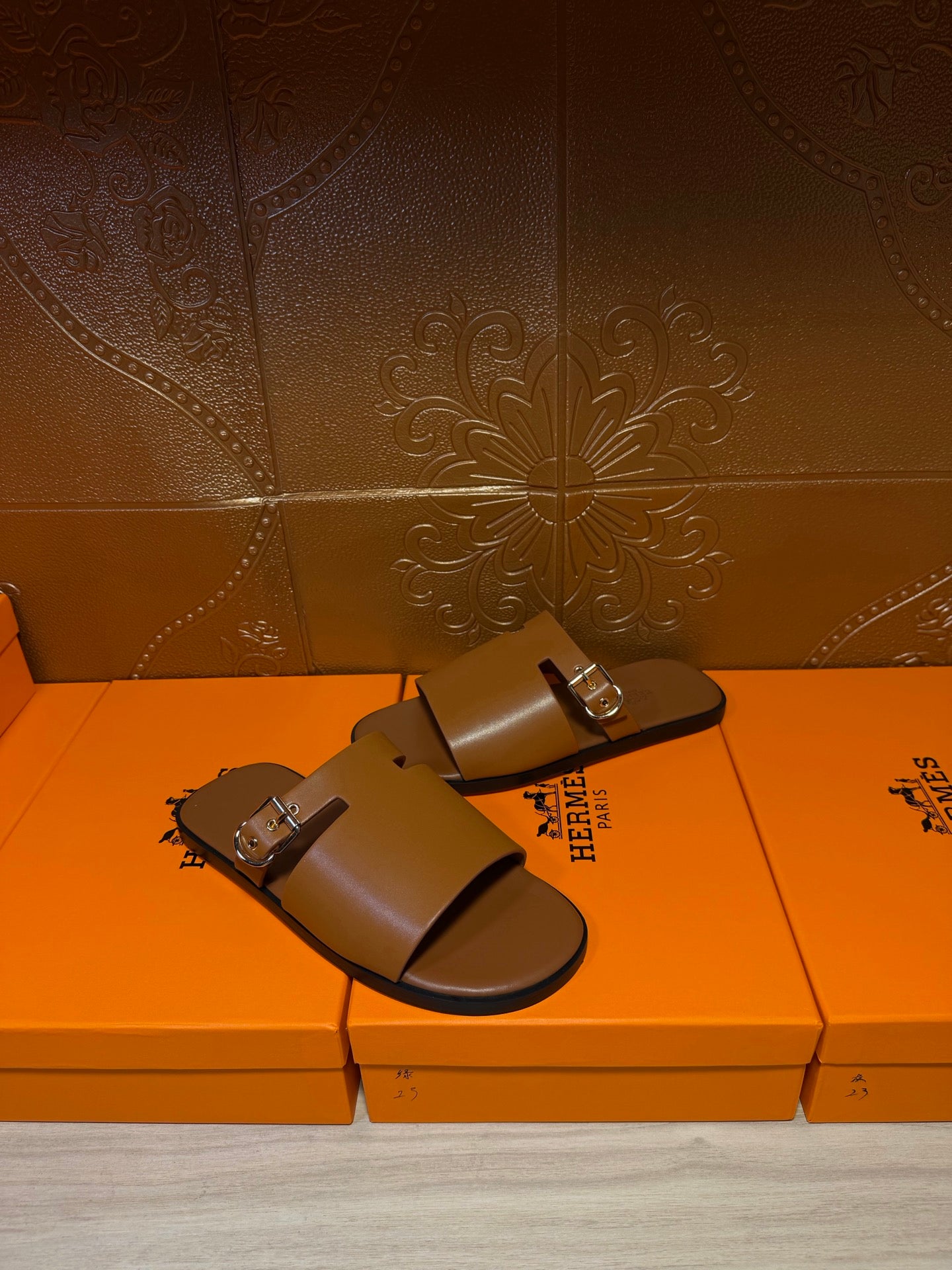 Hermes leather slide sandals with two silver buckles on wide straps, dark brown