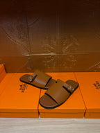 Hermes leather slide sandals with silver buckle strap detail, dark brown