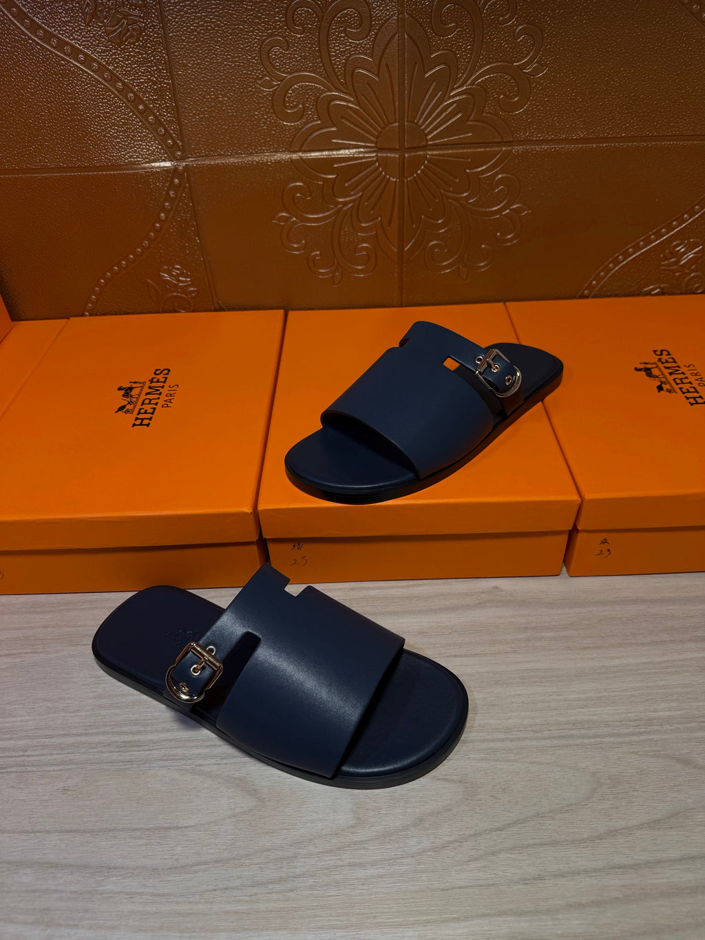 Hermes sandals, dark blue slip-on with two straps and gold buckle on the front.