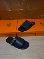 Hermes sandals, dark blue slip-on with two straps and gold buckle on the front.