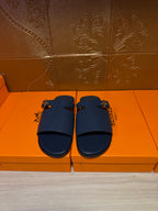 Hermes slide sandals in dark blue leather, double straps with gold buckle hardware.