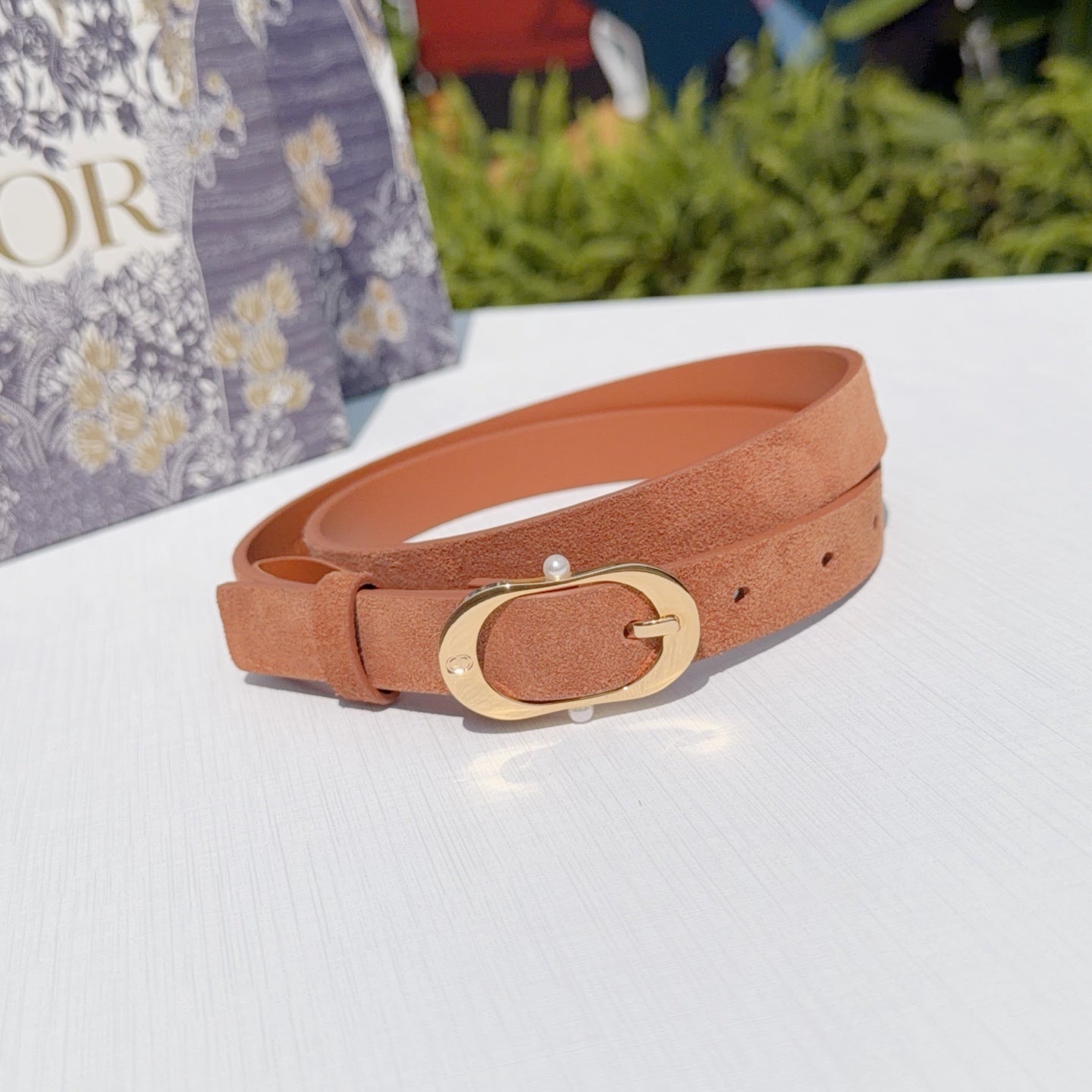 Tan leather belt with gold-tone oval buckle and small round stud detail