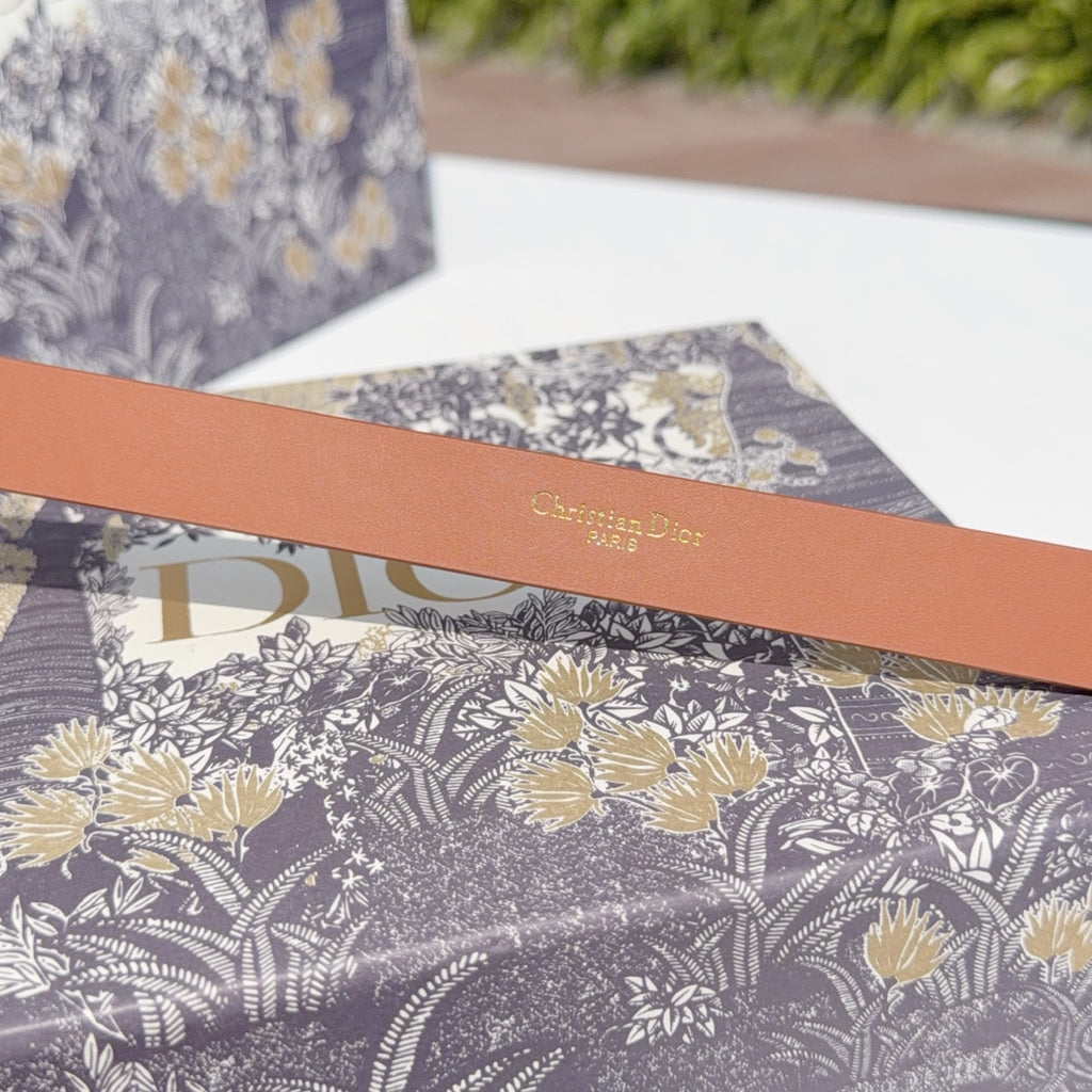 Tan leather belt with 'Christian Dior' text stamp