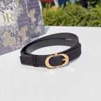 Dark leather belt with gold oval buckle on white tabletop