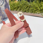 Rust leather belt with gold oval buckle and prong clasp