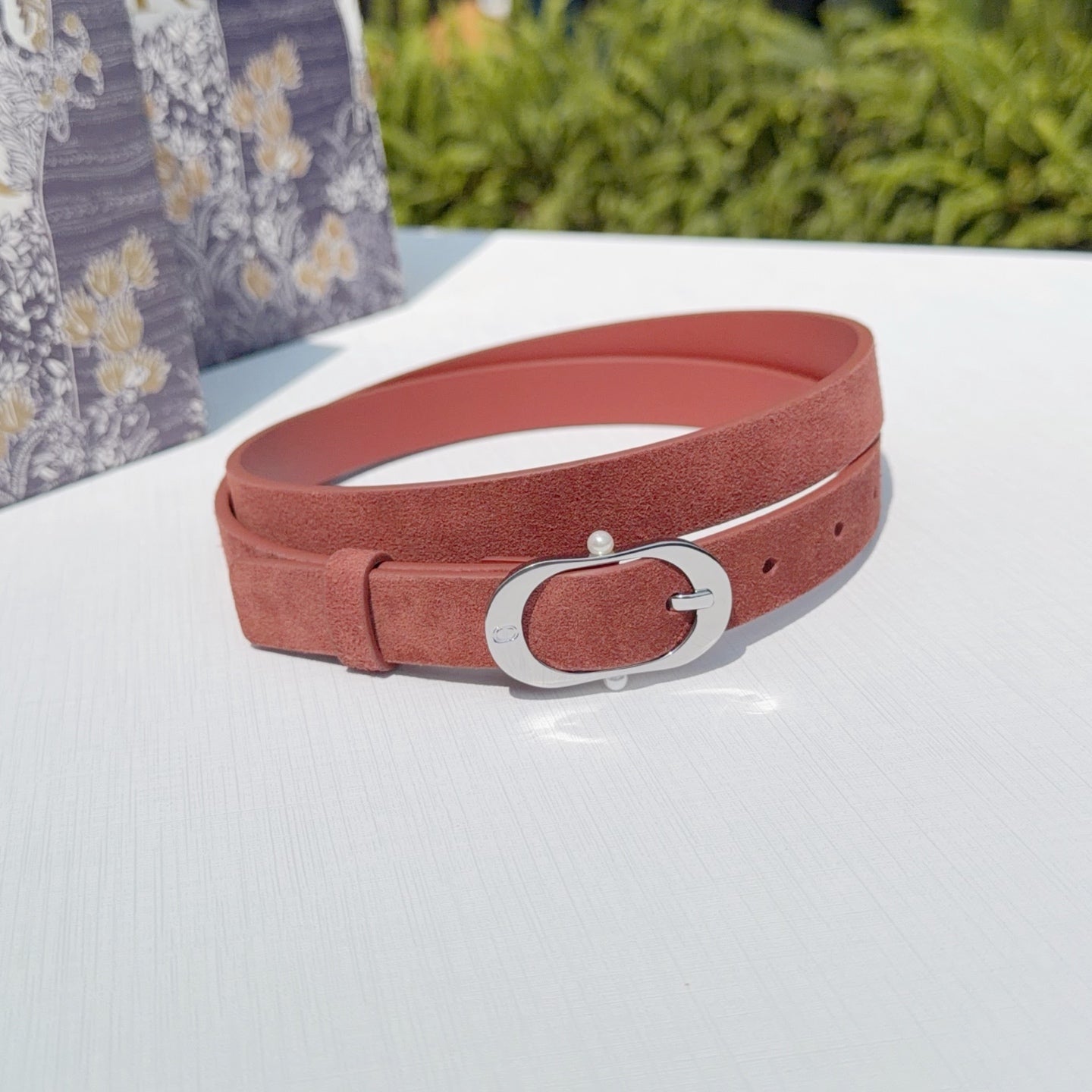 Reddish-brown leather belt with silver buckle and center oval frame