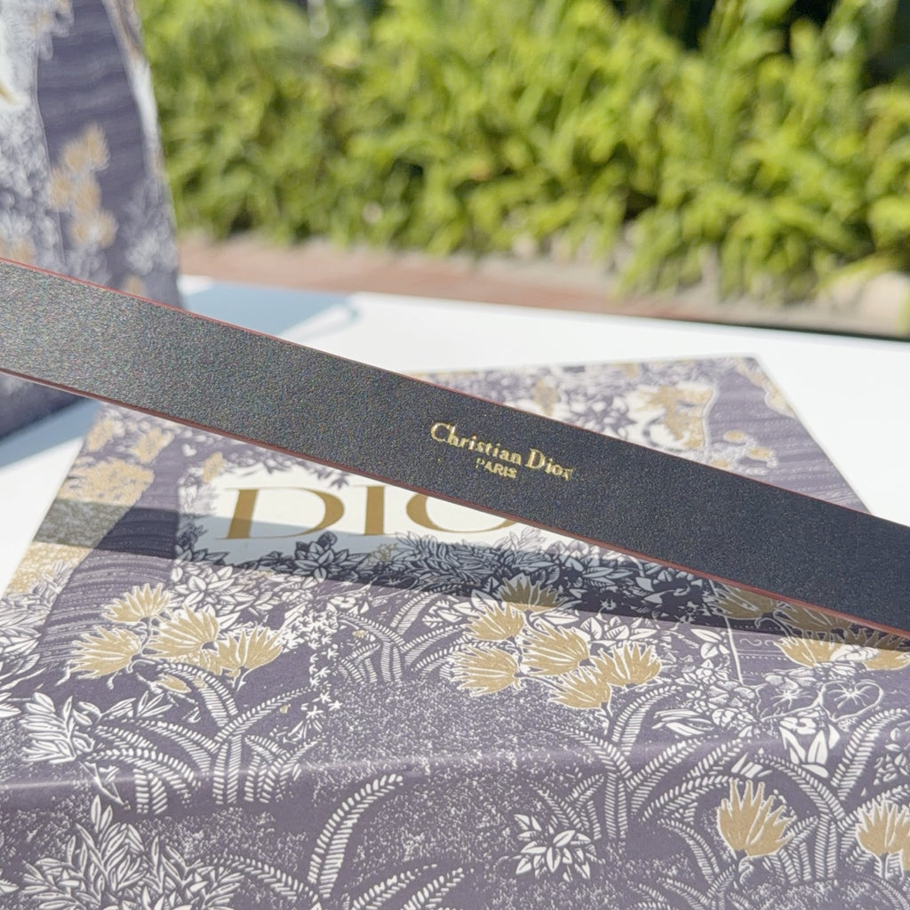 Grey leather belt underside with 'Christian Dior' stamped above 'Dior' lettering