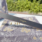 Grey leather belt underside with 'Christian Dior' stamped above 'Dior' lettering