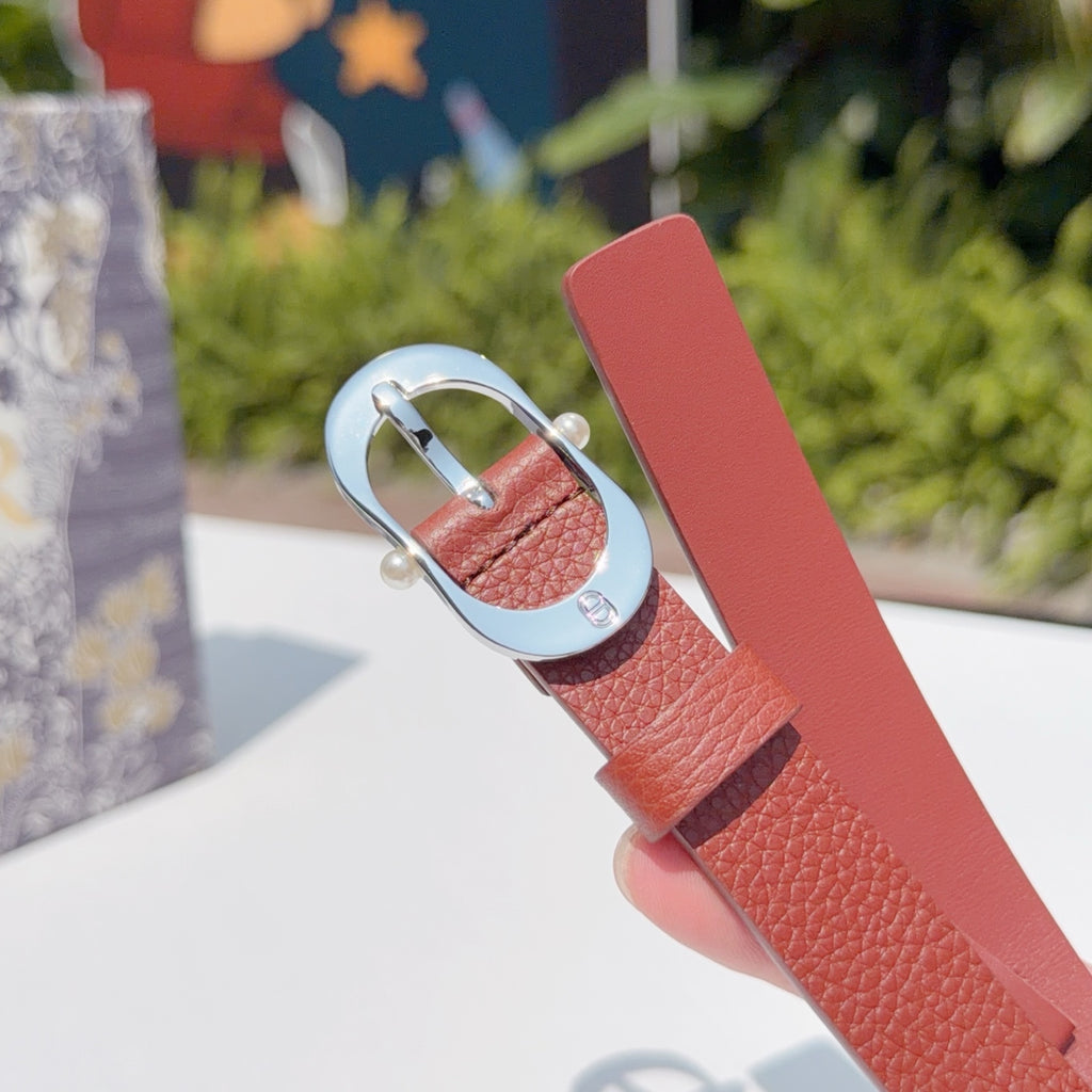 Red leather belt tip with silver buckle loop and row of holes