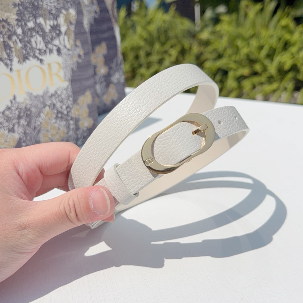 Leather belt held in hand, light gray strap with gold-tone buckle ring