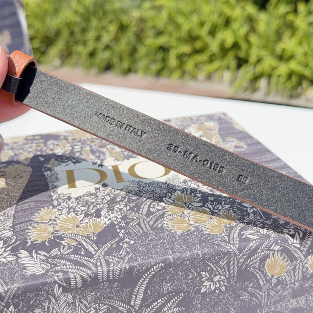 Dark belt strap with embossed text near the buckle