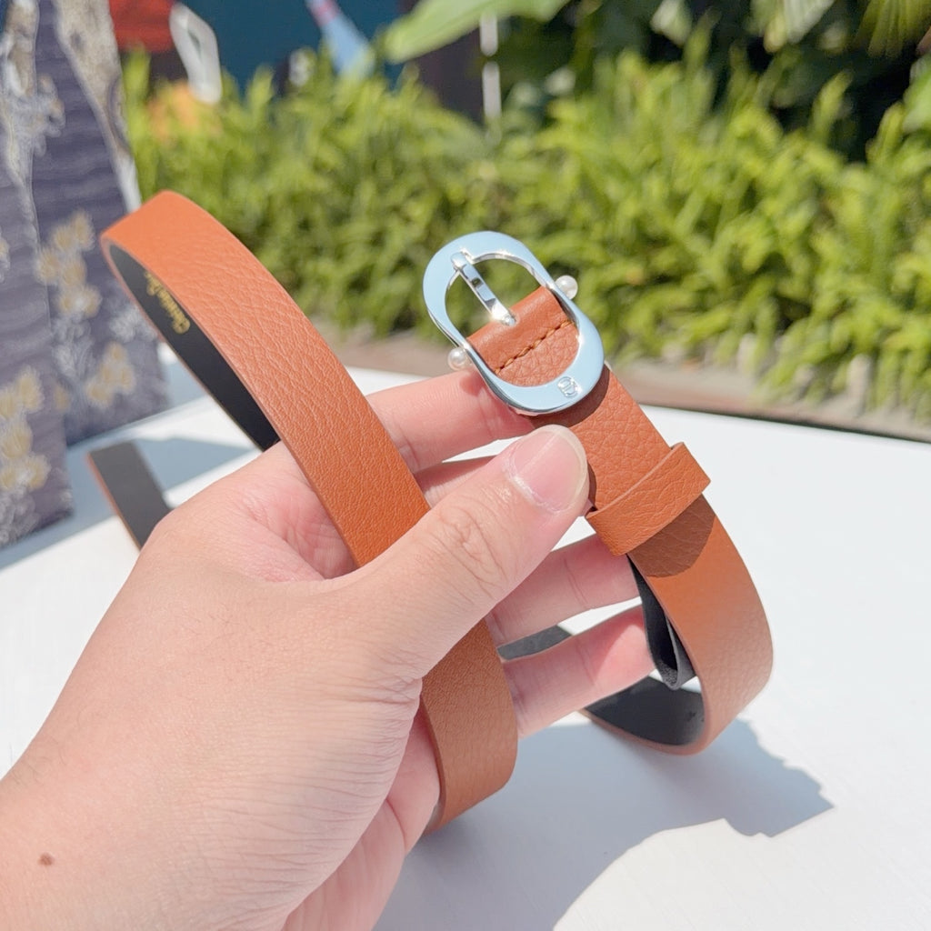 Leather belt with orange strap and silver-toned buckle, end with holes