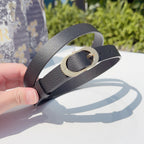 Dior belt detail: dark gray leather strap with gold-tone buckle and prong opening.