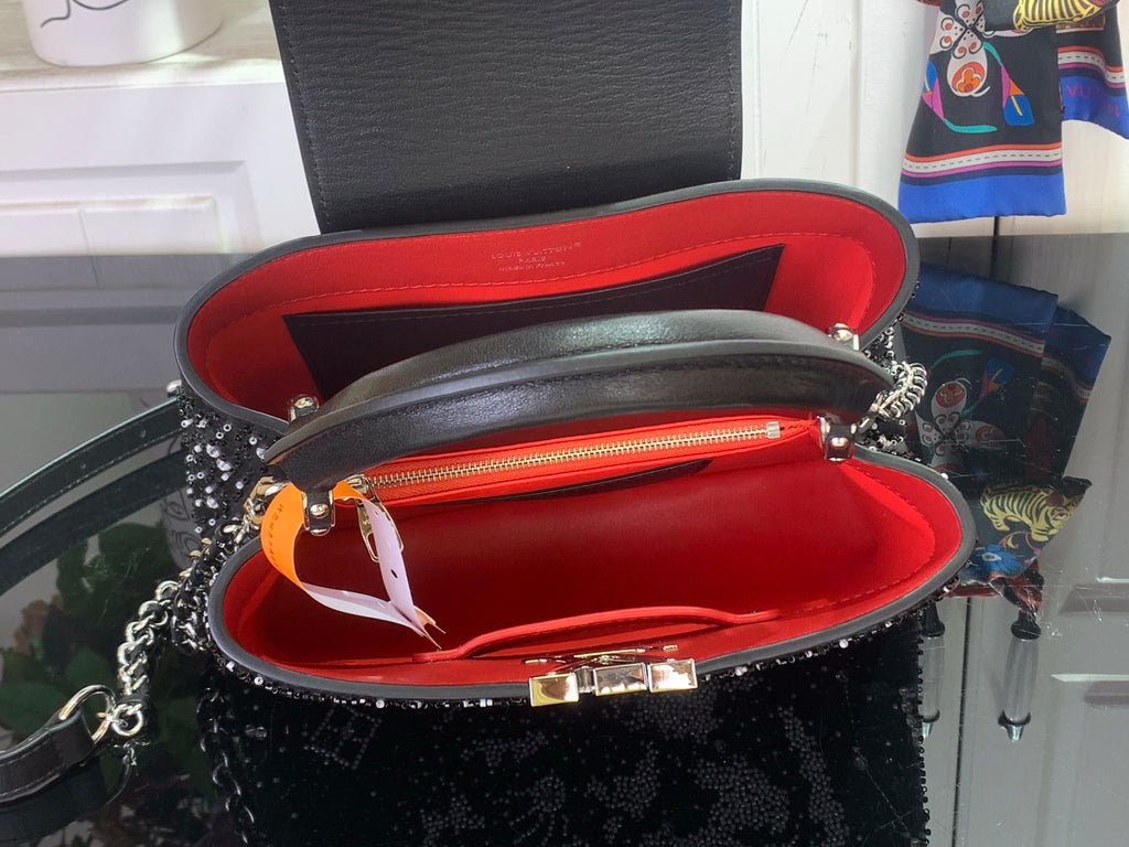 Louis Vuitton handbag open view, red interior lining with gold-tone clasp