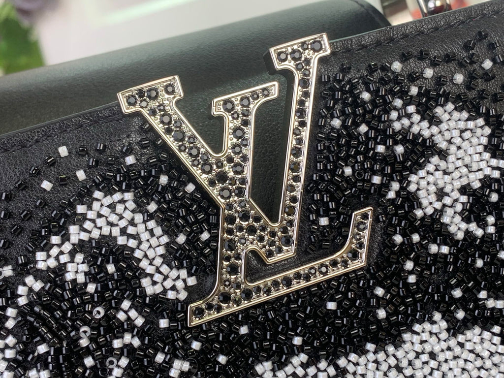 Louis Vuitton logo patch on black sequined handbag front with gold-toned trim
